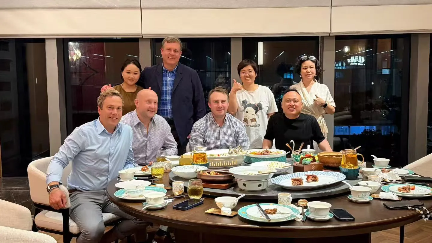 A group gathered around a dining table for a customer reception photograph